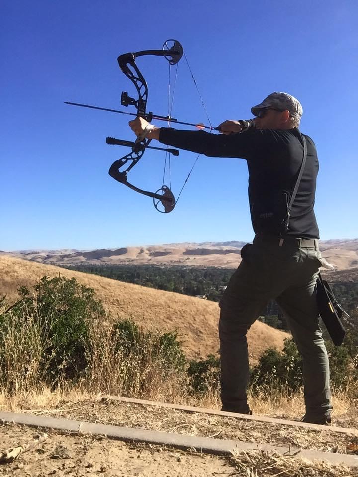 Andras practicing archery on a hillside